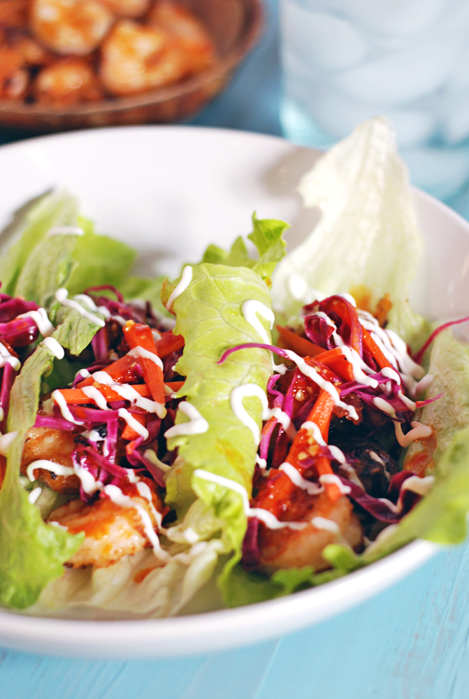 Fried Shrimp Lettuce Wraps with Pickled Vegetables, Chili Sauce, and Crema: A healthy seafood lettuce wrap is paired with beautifully pickled cabbage and carrots, spicy hot chili sauce, and refreshing crema.